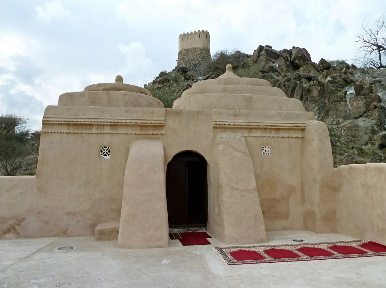 Al Bidya Mosque, a small stone and mud-brick mosque on the Fujairah coast, with a watchtower on the hill behind
