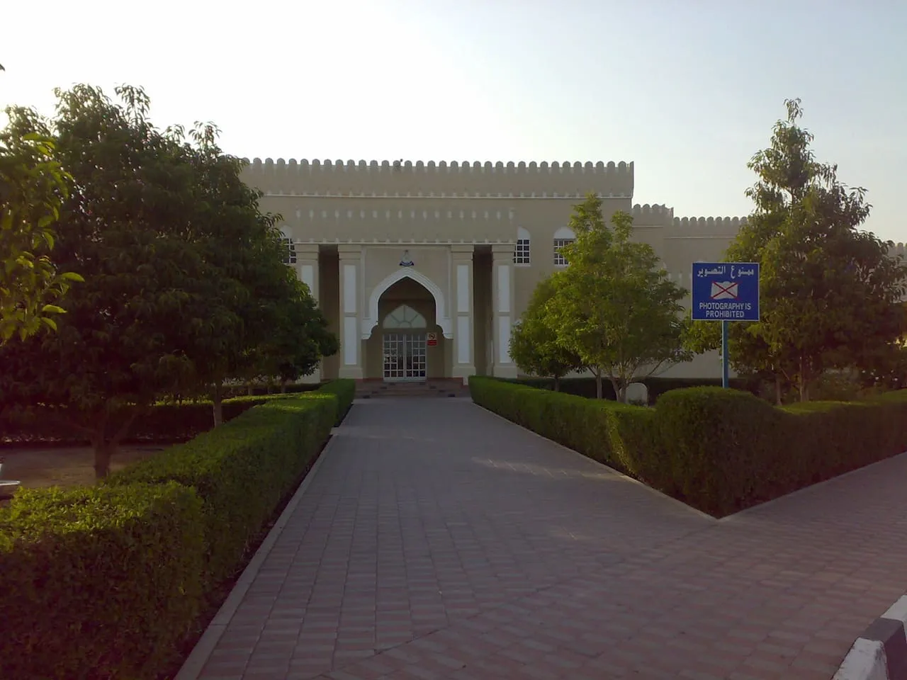 The Omani border post building at Al Wajajah, with a no-photography sign beside the entrance path
