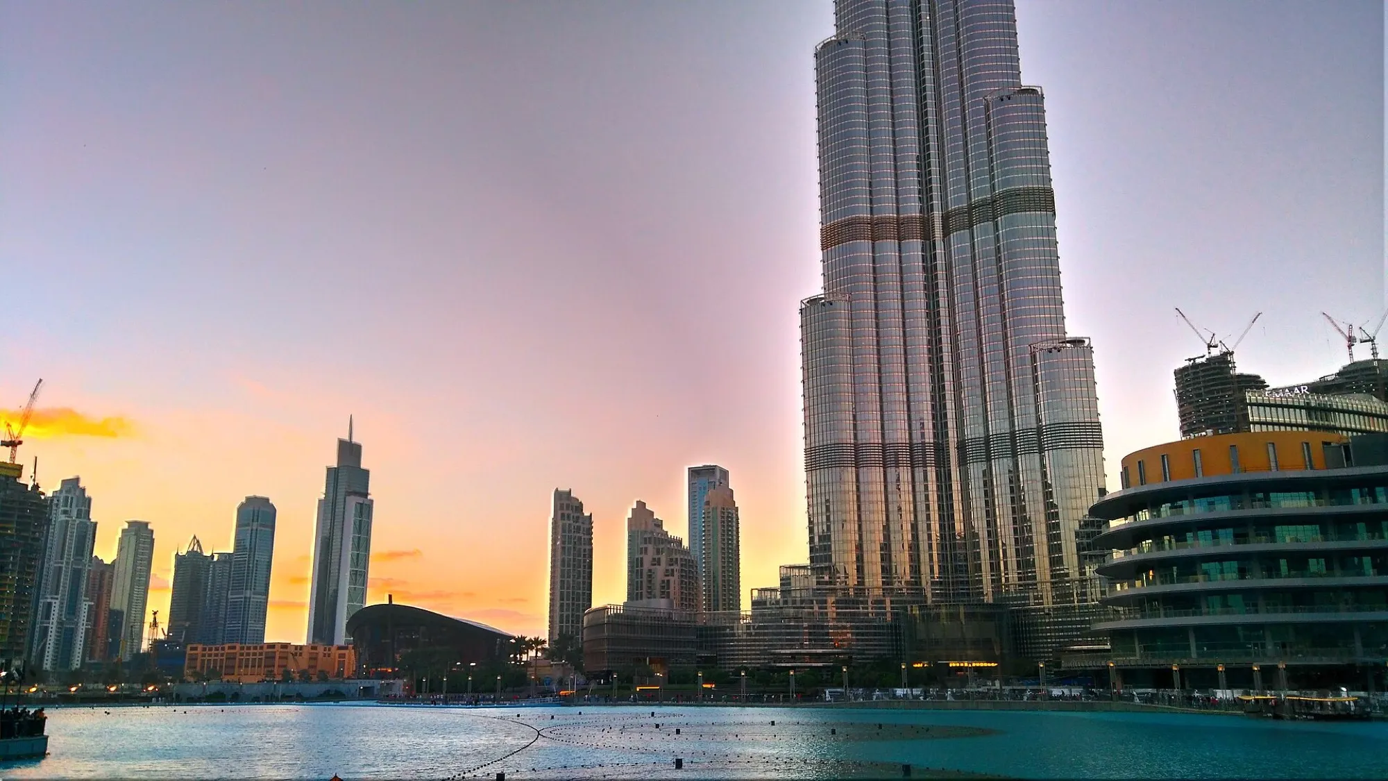 The Burj Khalifa at dusk beside the water of the Dubai Fountain in Downtown Dubai