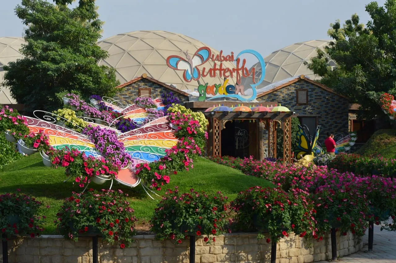 The entrance to Dubai Butterfly Garden, with a flower butterfly in front of its domes