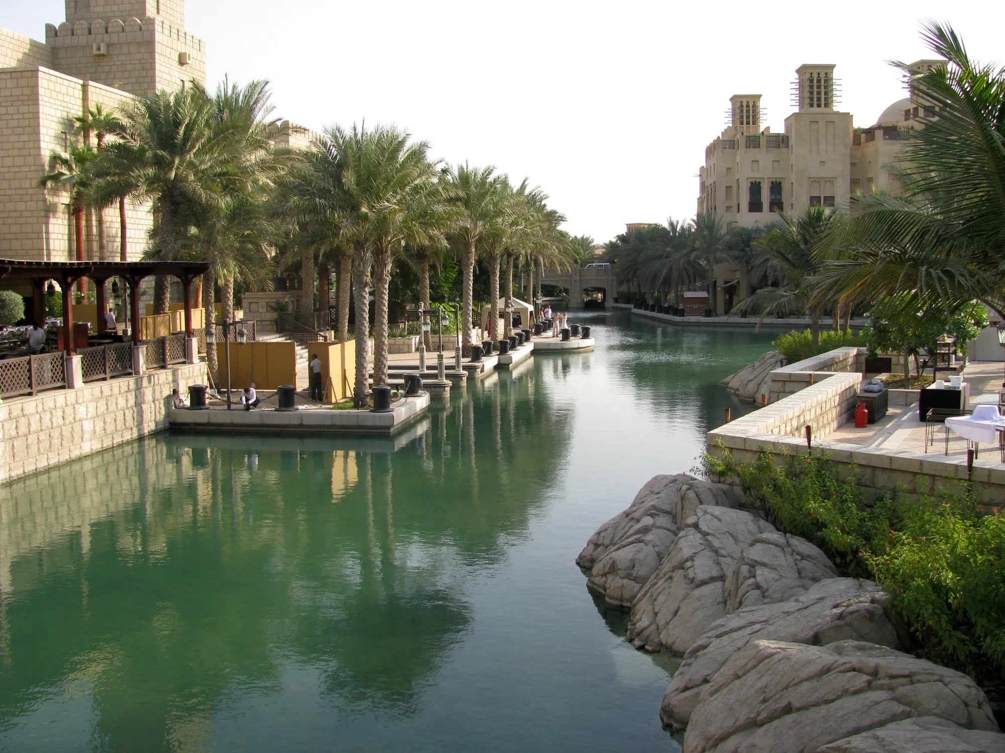 A waterway at Madinat Jumeirah lined with date palms and wind-tower buildings