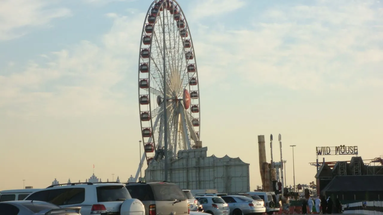 Parked cars in front of the Festival Wheel at Global Village