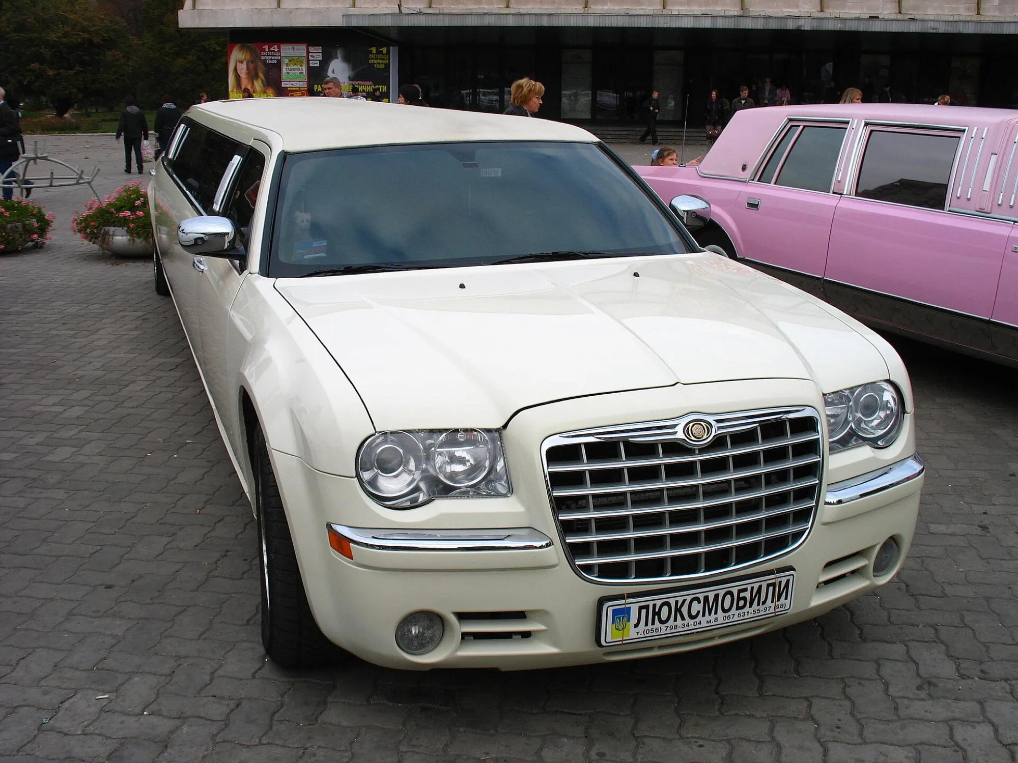 A cream Chrysler 300C stretch limousine parked on paving