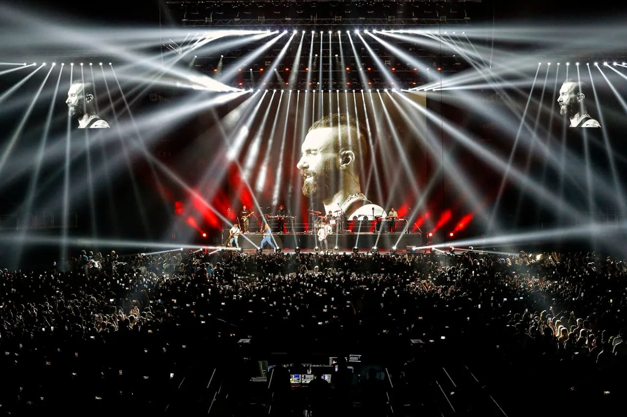 A concert crowd under stage lights at Coca-Cola Arena, Dubai