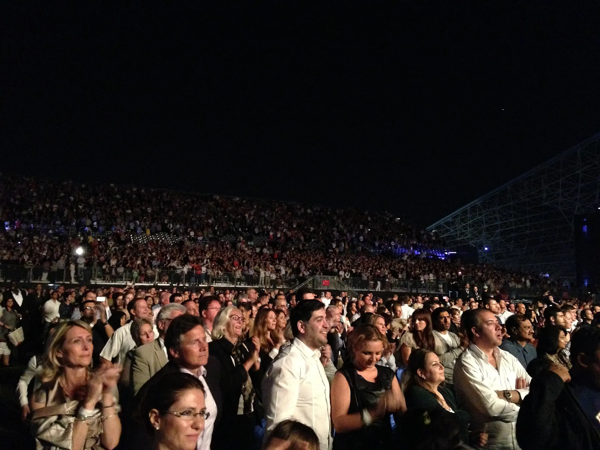 A packed evening concert crowd at an open-air arena in Abu Dhabi