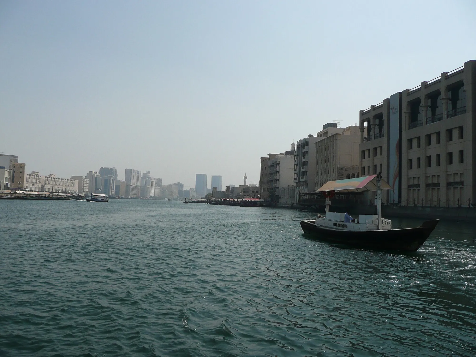 An abra crossing Dubai Creek with the Deira waterfront behind it
