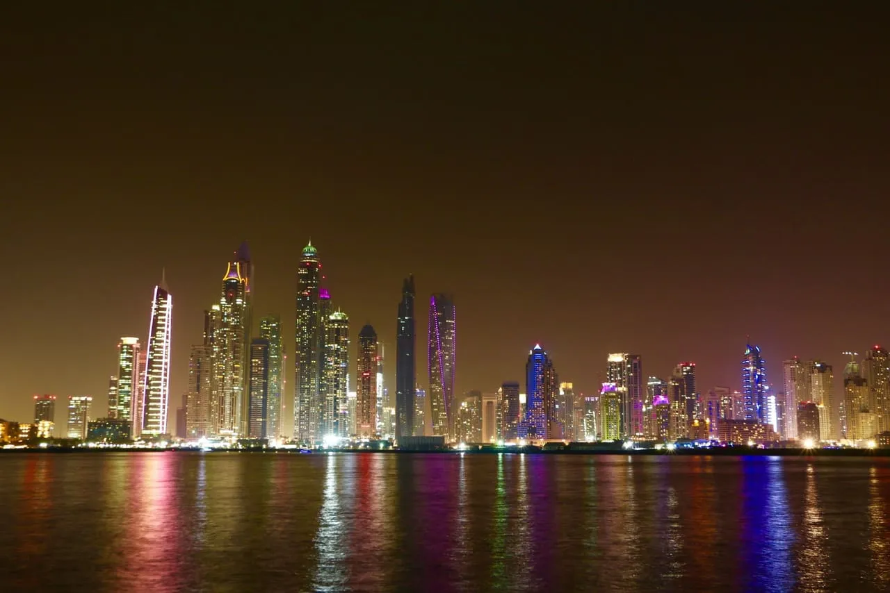 The towers of Dubai Marina lit up at night and reflected in the water