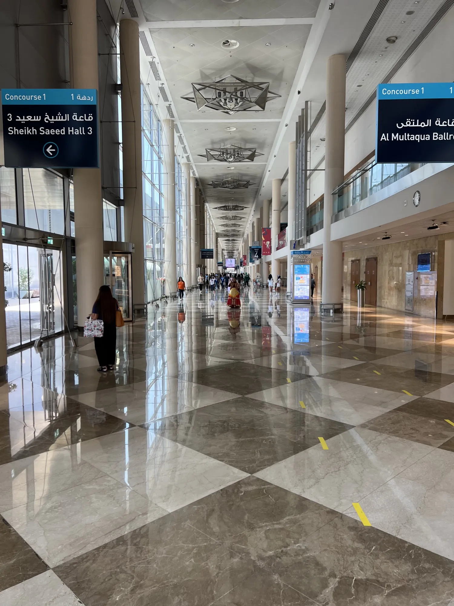 A DWTC concourse with signs to Sheikh Saeed Hall 3 and Al Multaqa Ballroom
