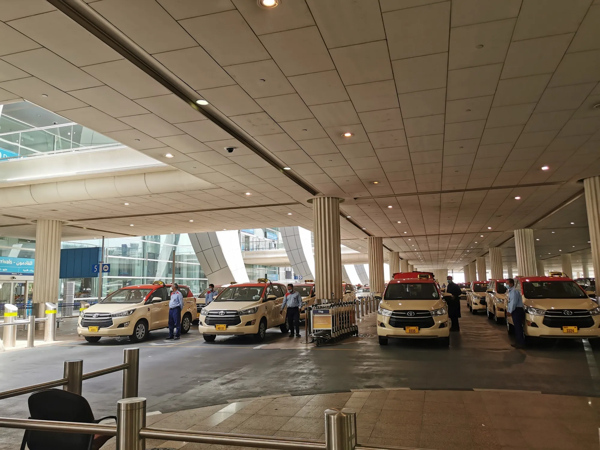 Dubai Taxi cars lined up at the rank under the arrivals canopy at Dubai International