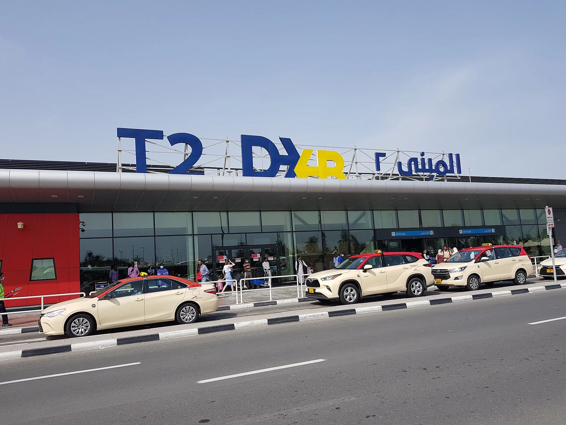 The arrivals entrance of DXB Terminal 2, with Dubai taxis waiting at the kerb
