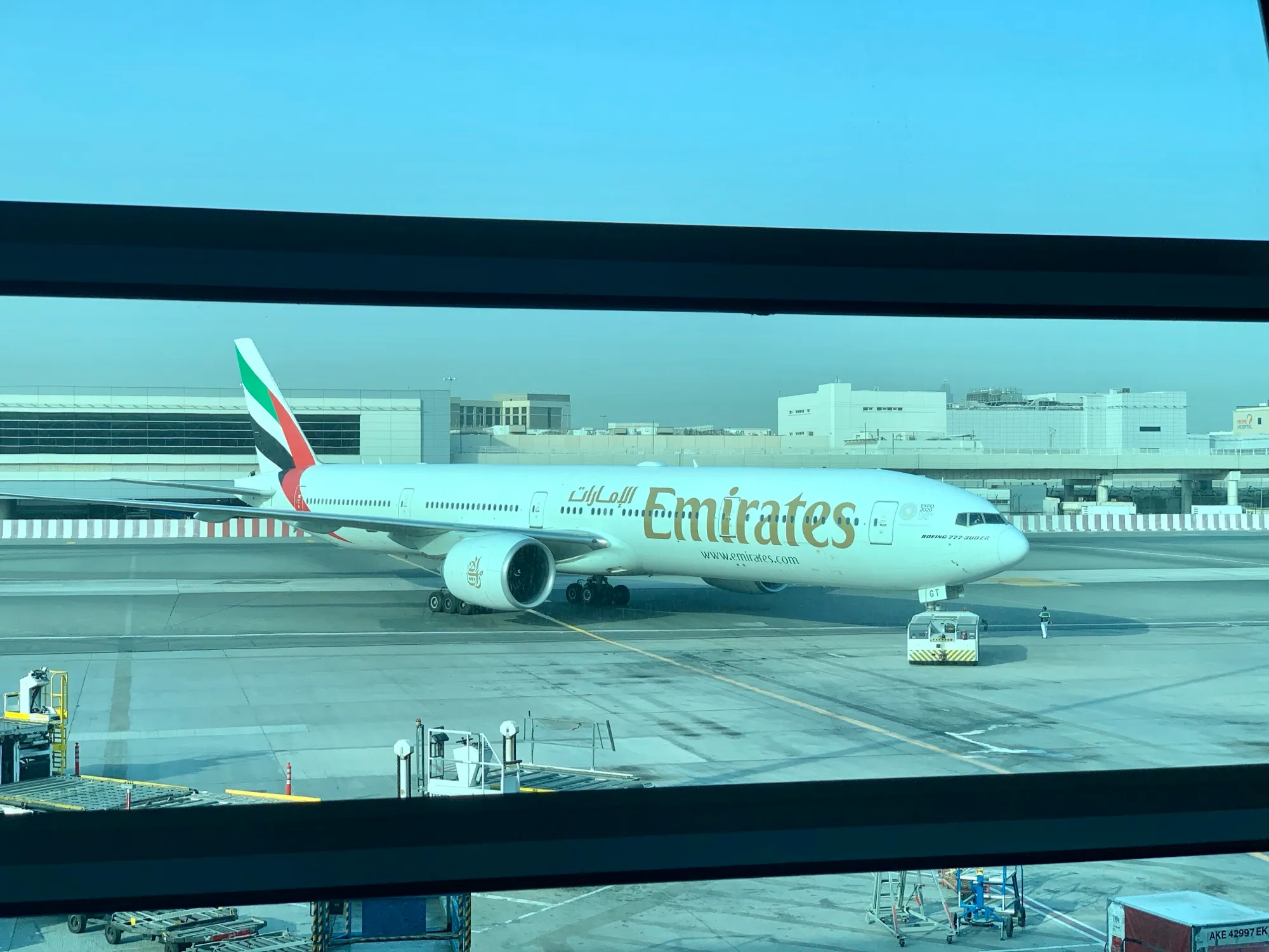 An Emirates Boeing 777-300ER on the apron, seen from a Terminal 3 window at Dubai International