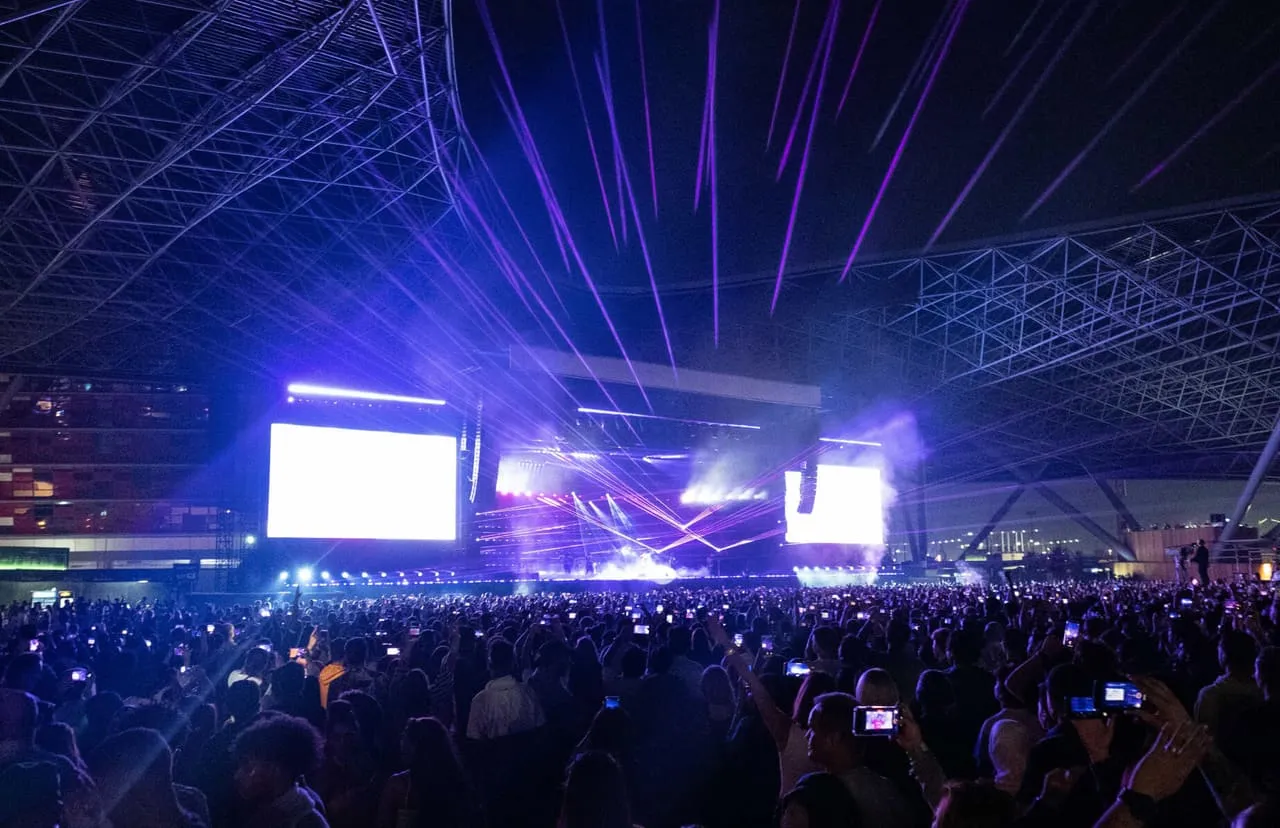 A night-time concert crowd under the lighting rig at Etihad Park on Yas Island