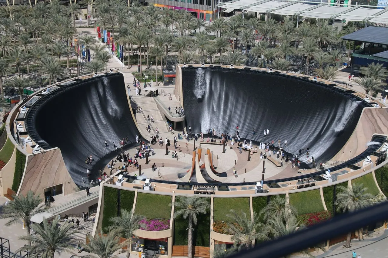 The water feature at Expo City Dubai seen from above, ringed by palm-lined walkways
