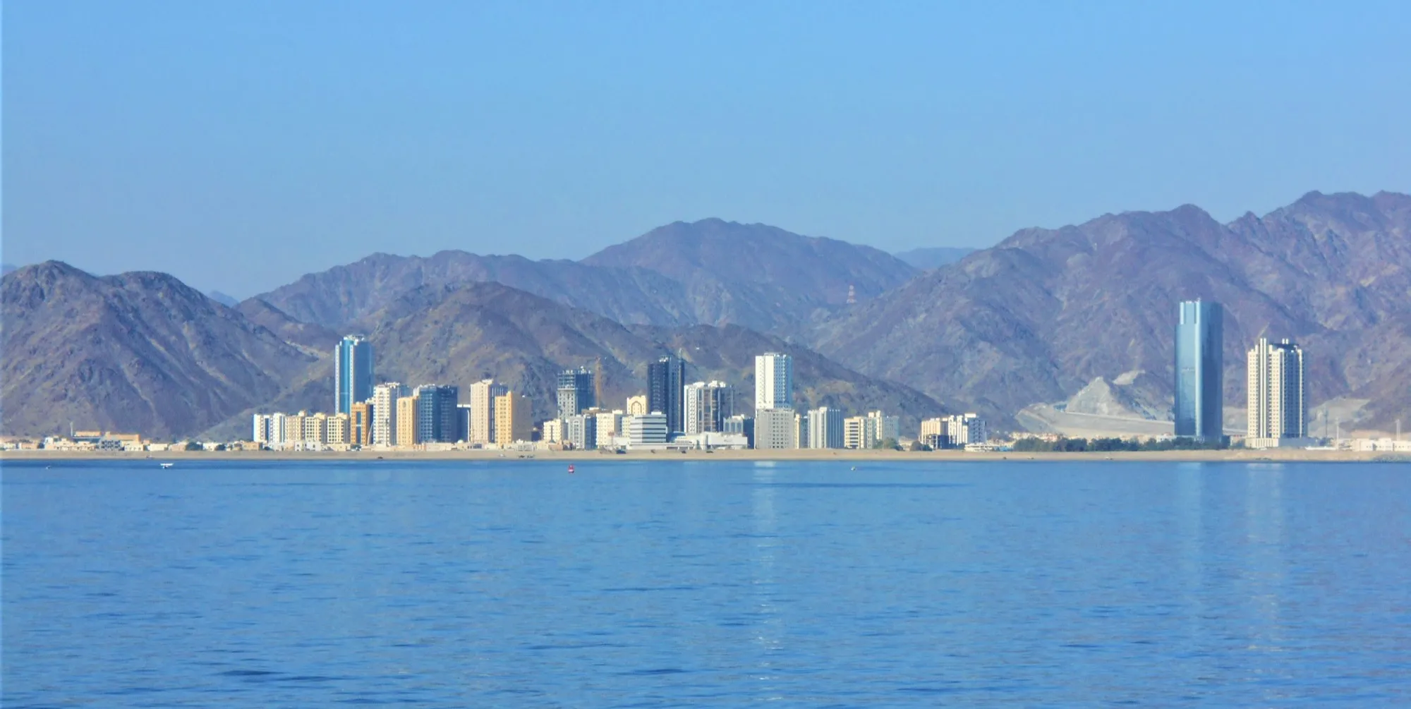 Fujairah city towers on the shoreline with the Hajar mountains behind
