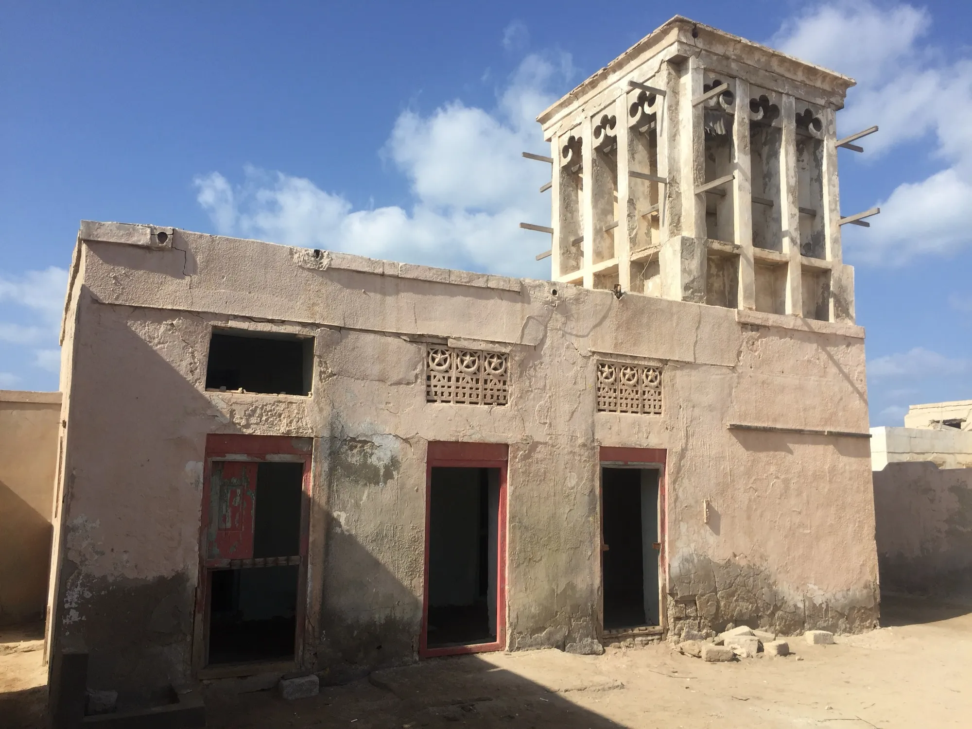 A weathered house with a wind tower in the abandoned village of Al Jazirat Al Hamra