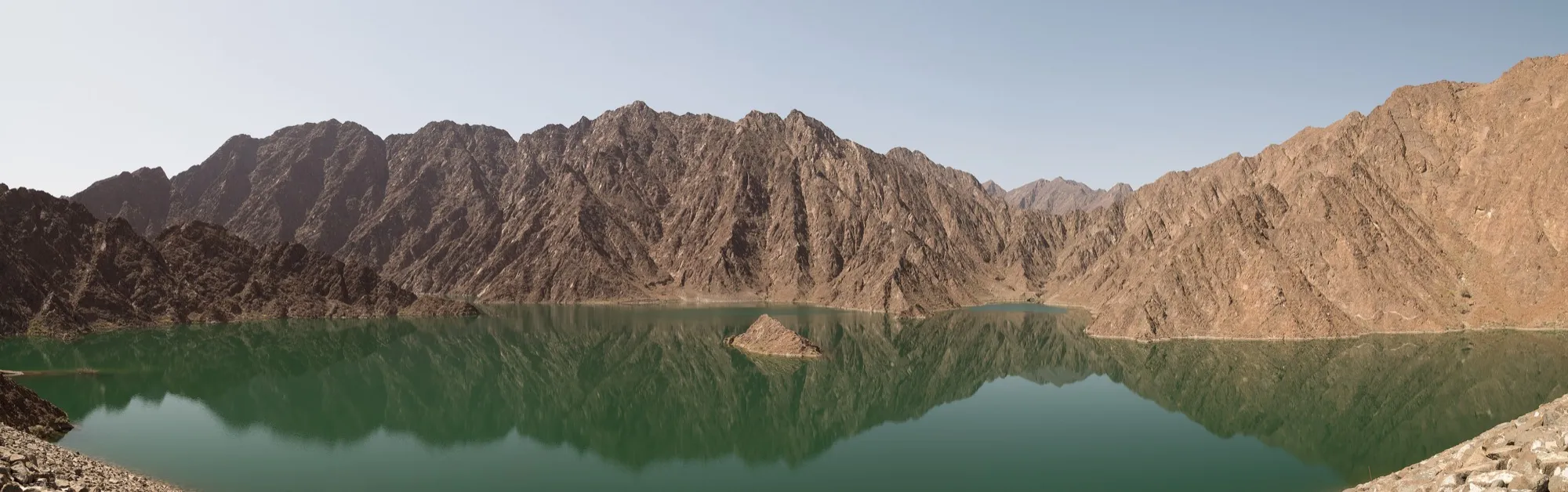 Panorama of Hatta Dam reservoir reflecting the Hajar Mountains