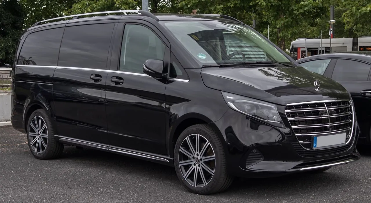 A black long-wheelbase Mercedes-Benz V-Class V 300 d with chrome grille and sliding side door, parked in a car park