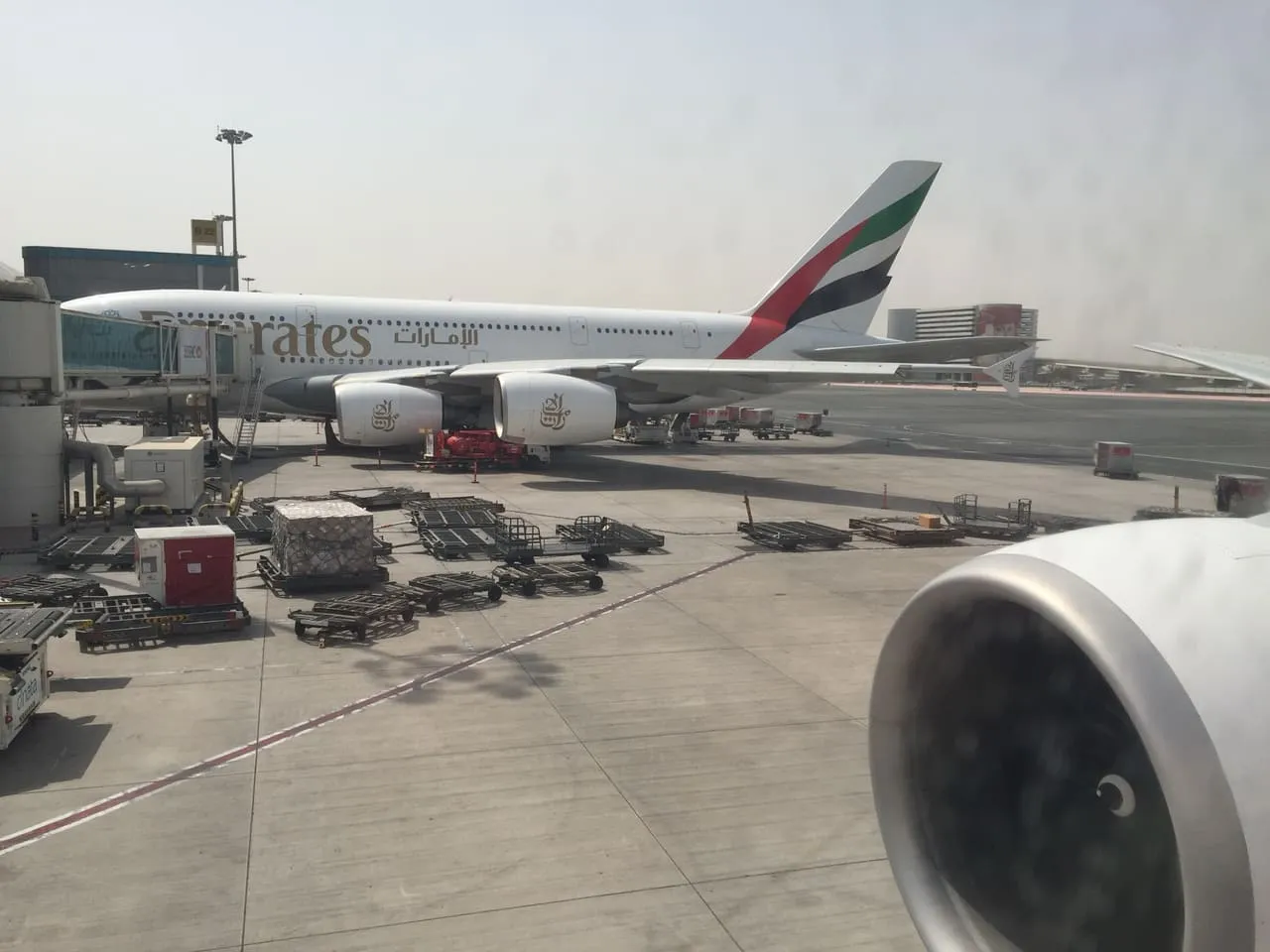 An Emirates Airbus A380 parked at a B gate at Dubai International Airport, seen from another Emirates aircraft