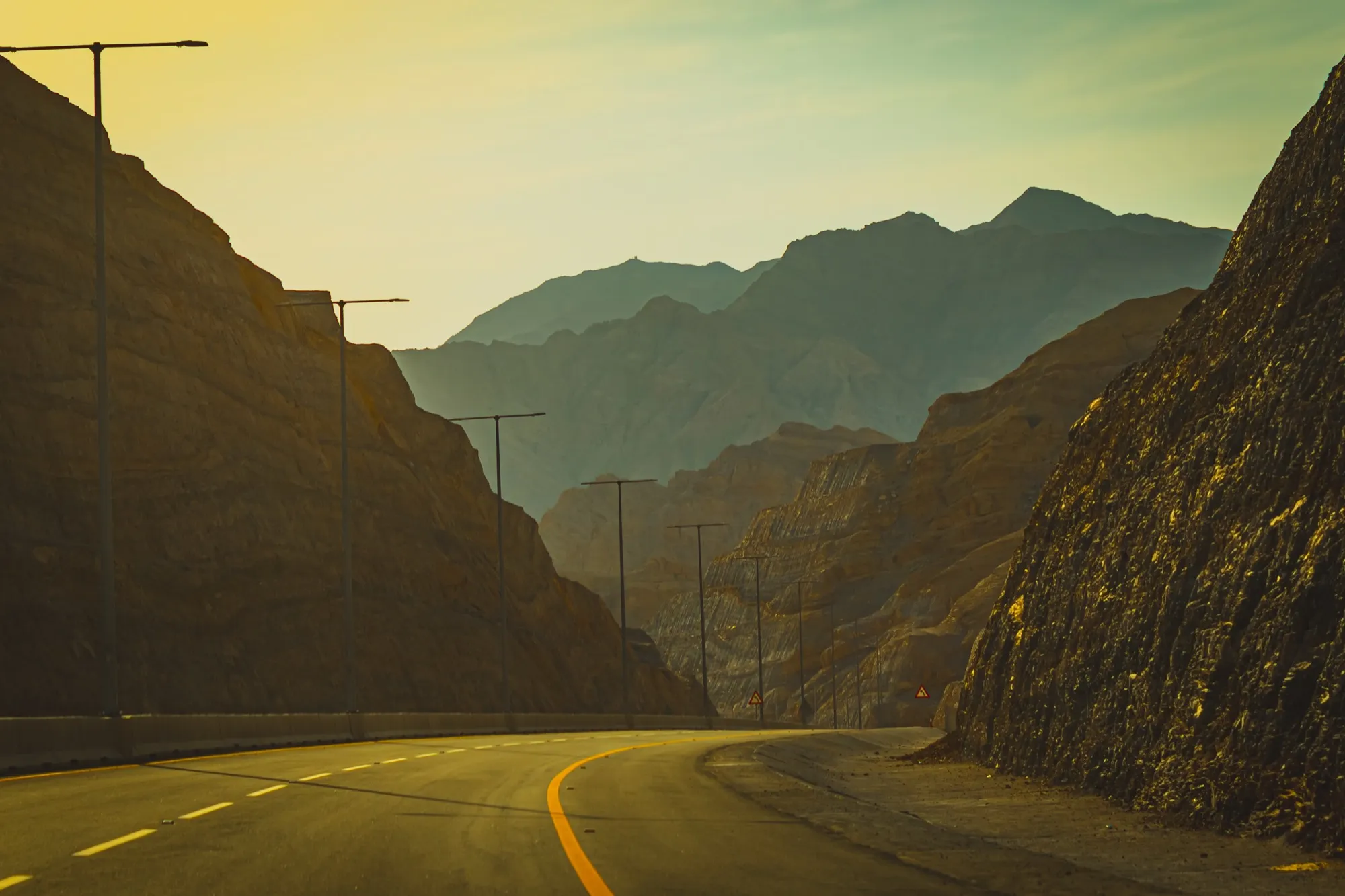 The road to Jebel Jais cutting between rock walls in the Hajar Mountains at dusk