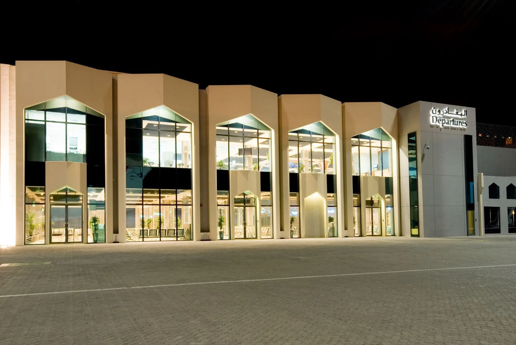 The departures entrance of Fujairah International Airport's terminal building, lit at night