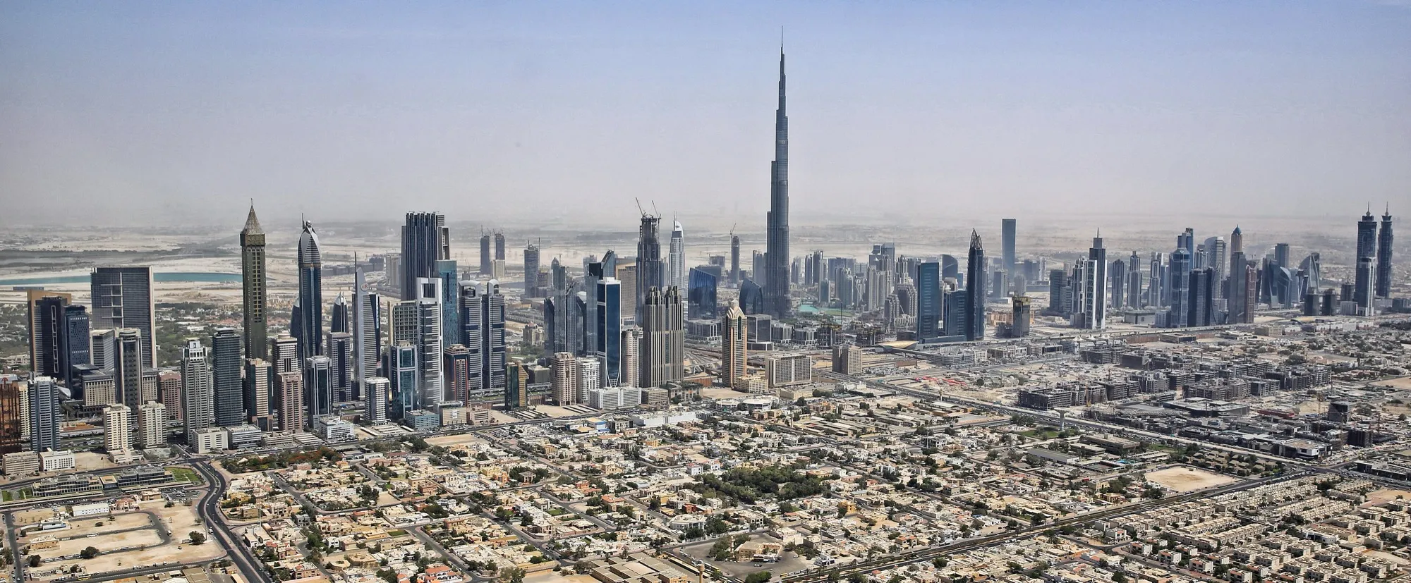 Aerial view of Downtown Dubai with the Burj Khalifa rising above Sheikh Zayed Road and the city