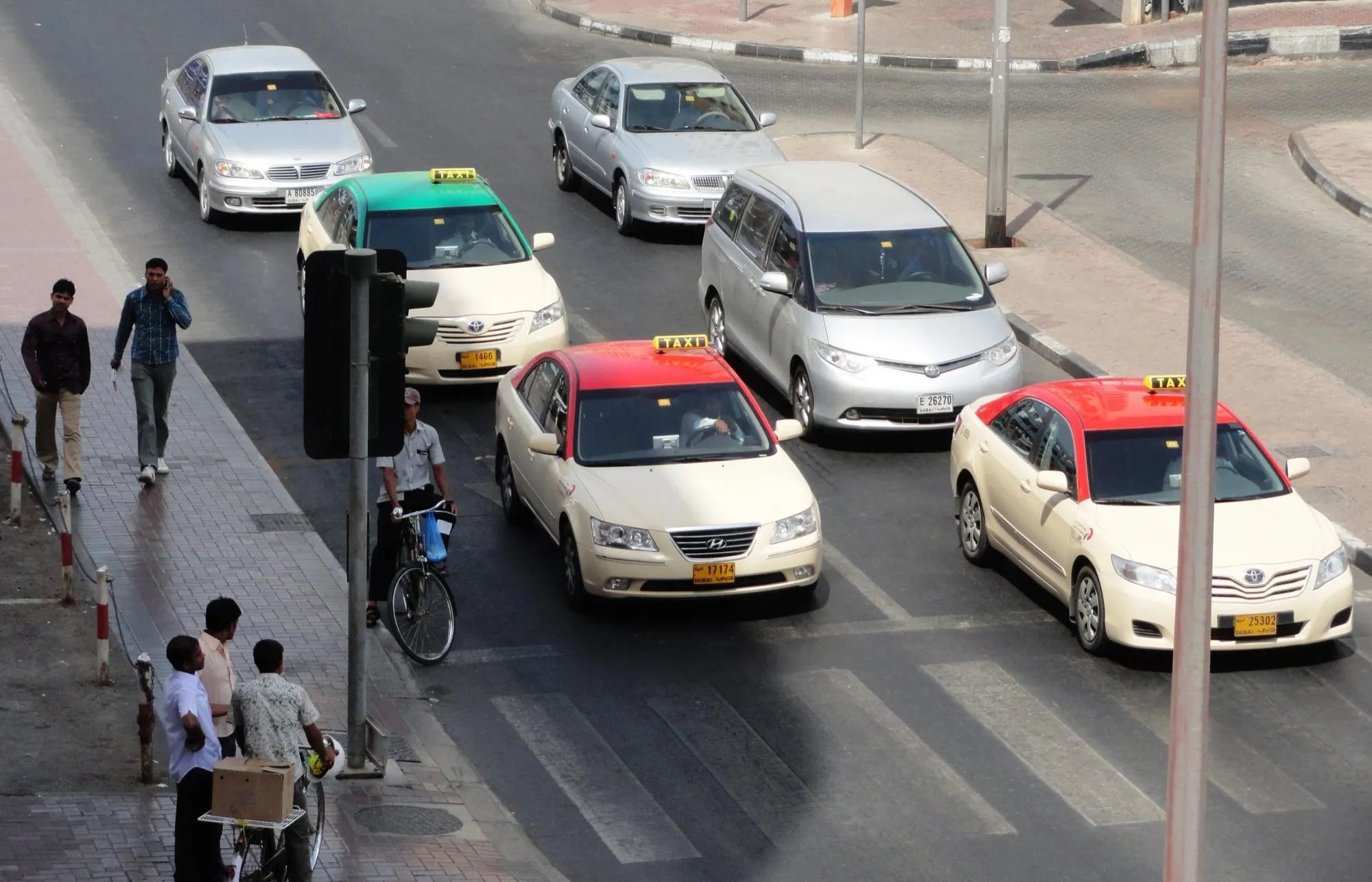 Dubai taxis with red and green roofs waiting at a junction in Bur Dubai