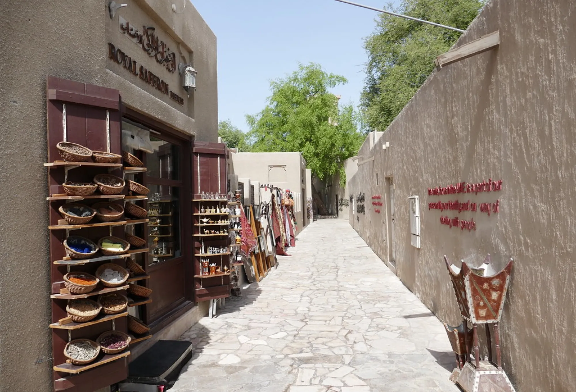 A narrow stone-paved lane in the Al Fahidi Historical Neighbourhood, Dubai, with a spice shop on the left