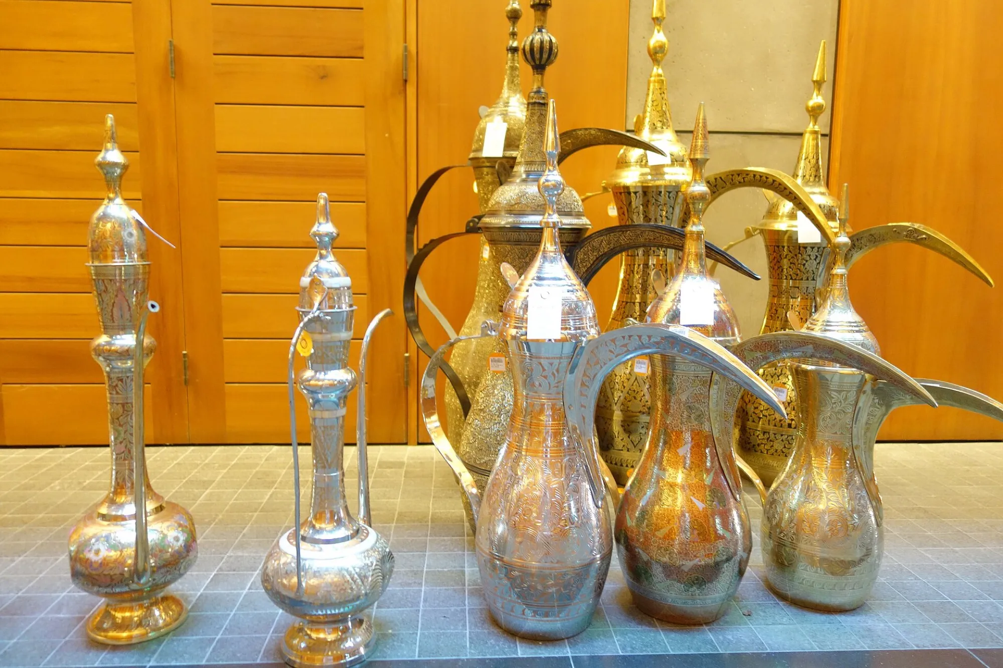 A row of traditional brass dallah coffee pots