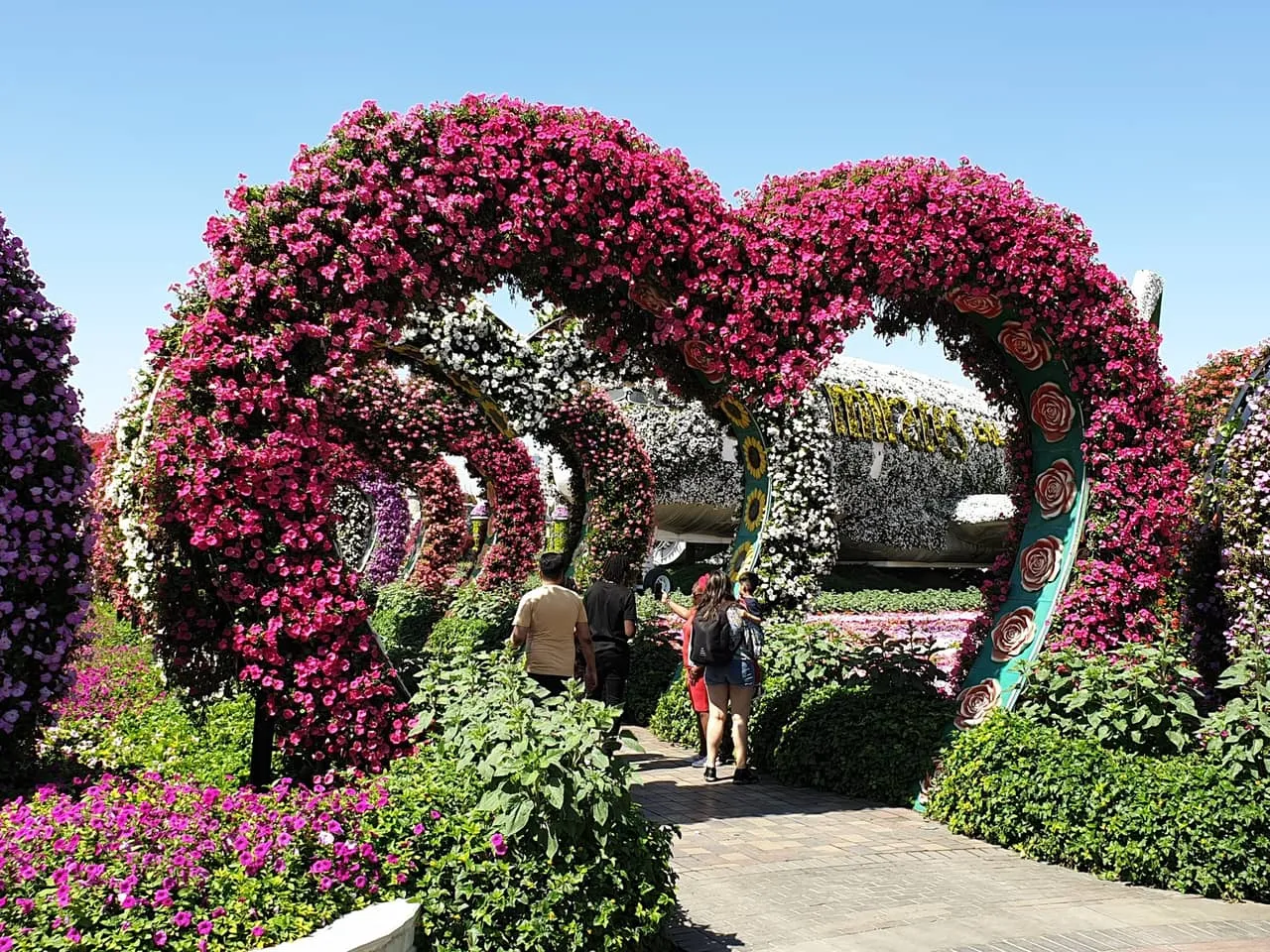 Heart-shaped flower arches over a path at Dubai Miracle Garden