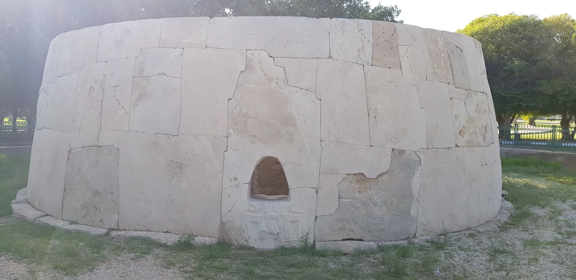The round limestone wall of the Hili Grand Tomb