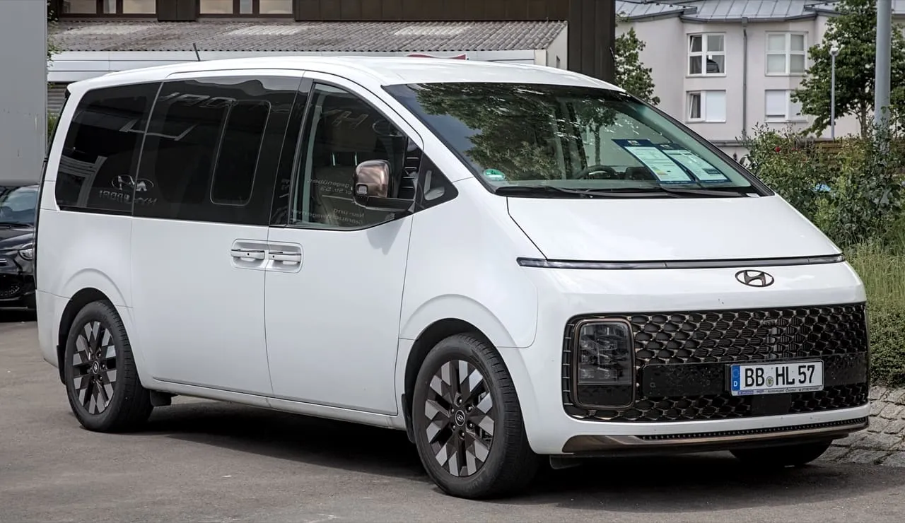 A white Hyundai Staria van with sliding side doors and tinted rear windows