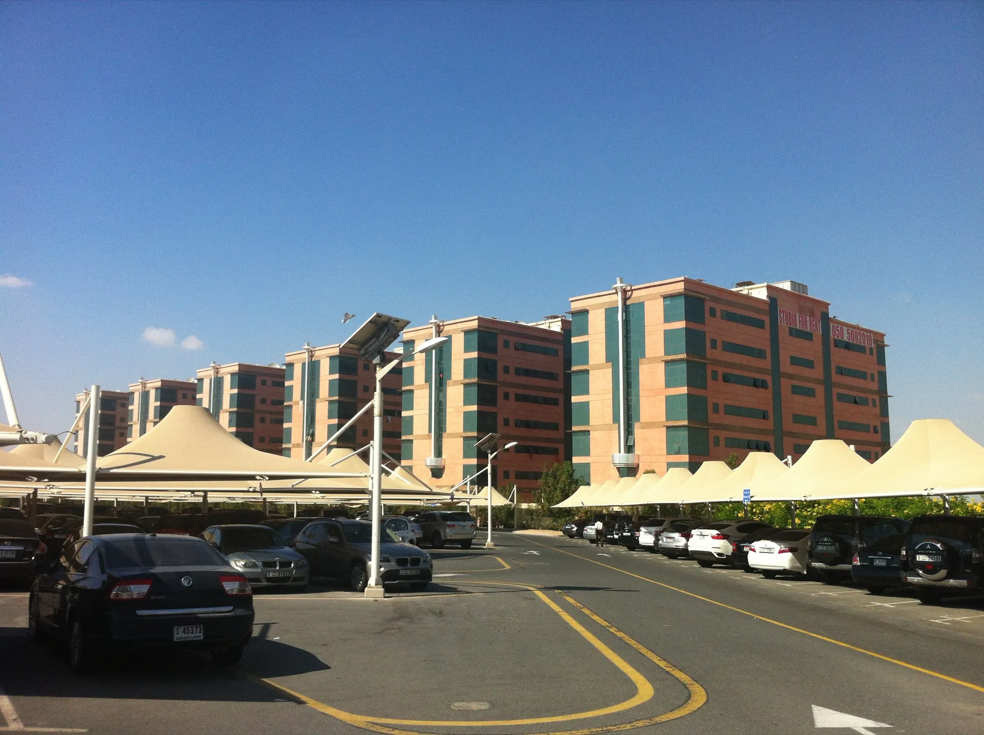 A shaded car park in Dubai with covered bays and cars in rows