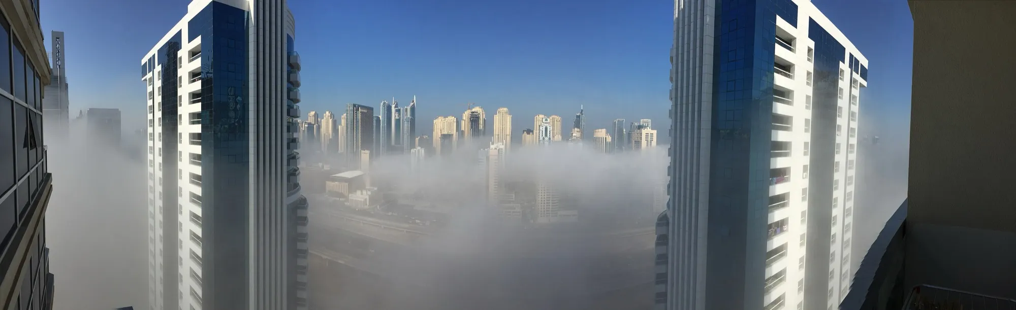 Dense morning fog covering the ground with Dubai Marina towers rising above it