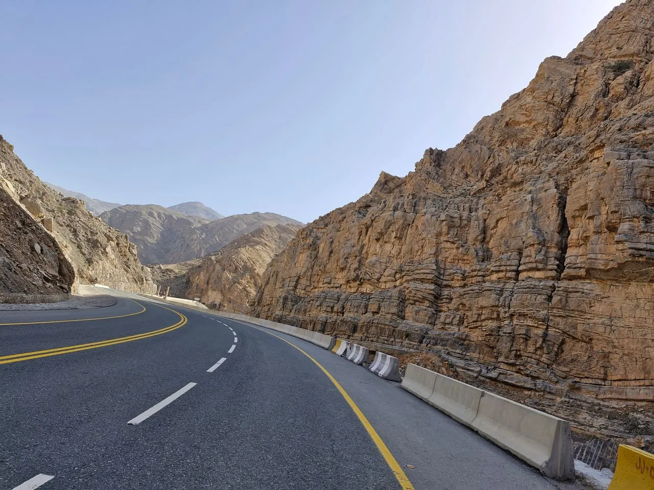 Jais Road passing through a cutting in layered rock on the way up Jebel Jais