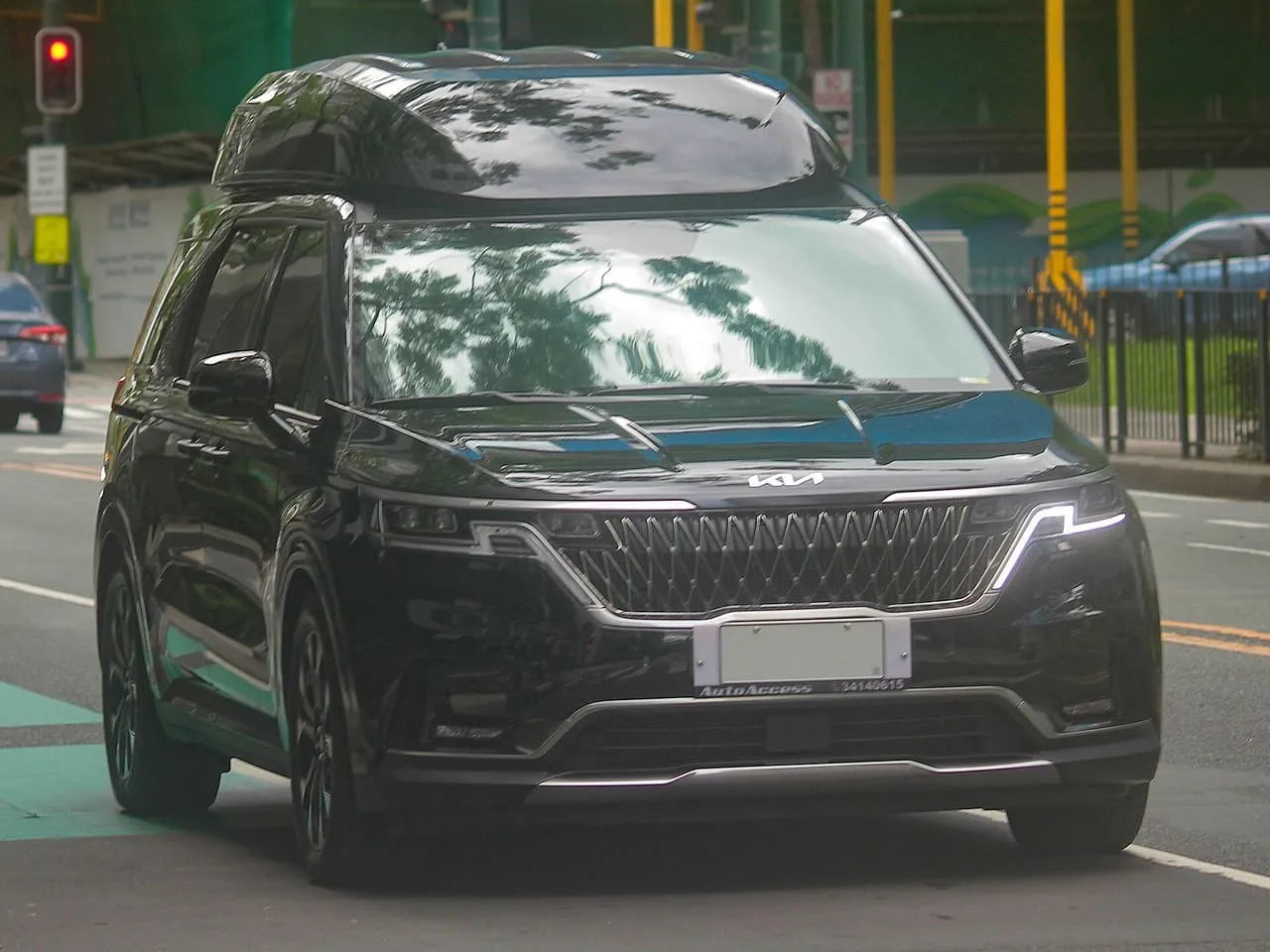 A black Kia Carnival people carrier seen from the front