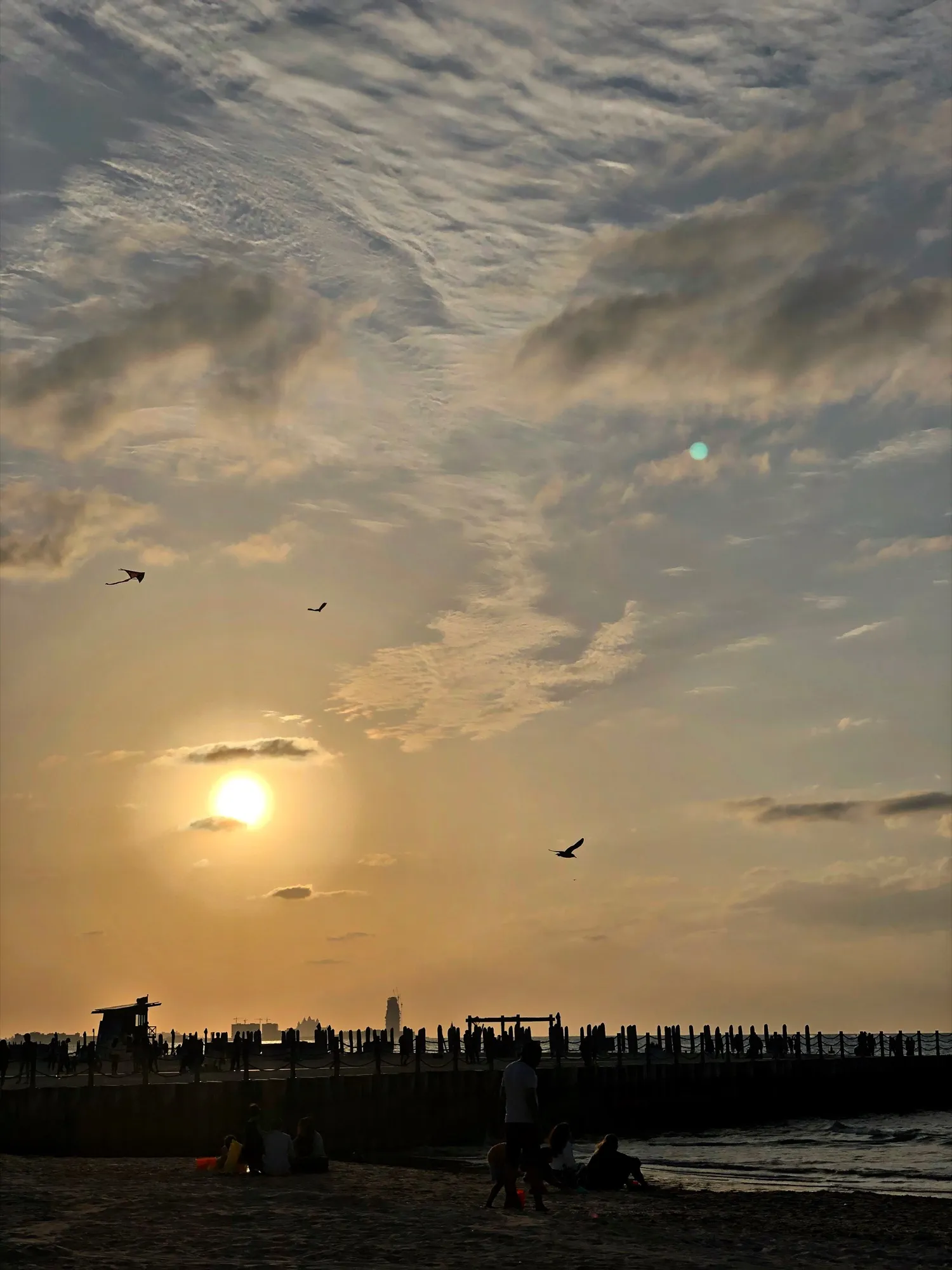The sun setting over Kite Beach in Dubai, with a lifeguard tower on the sand