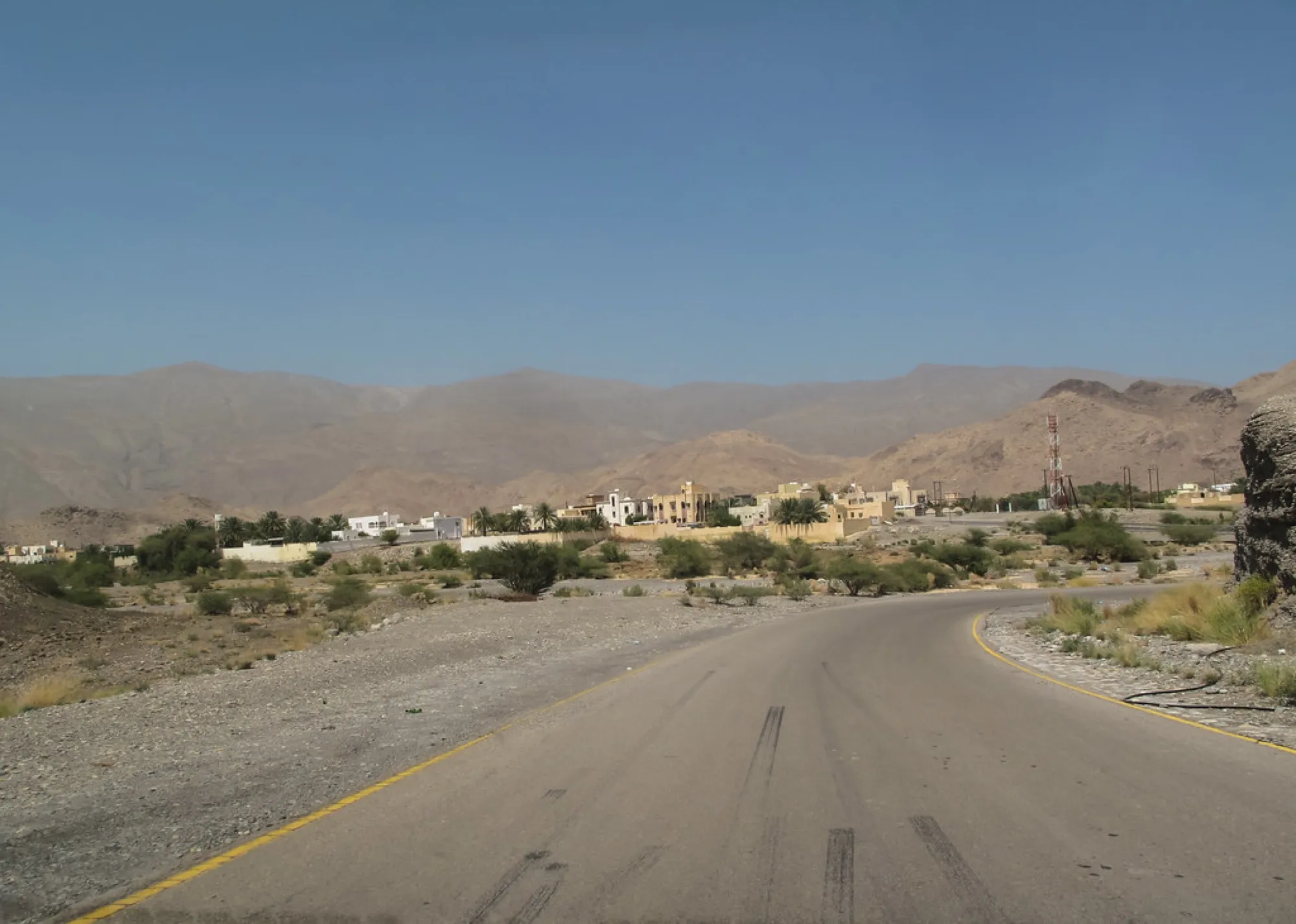 A winding road leaving Nizwa towards the Hajar Mountains in Oman
