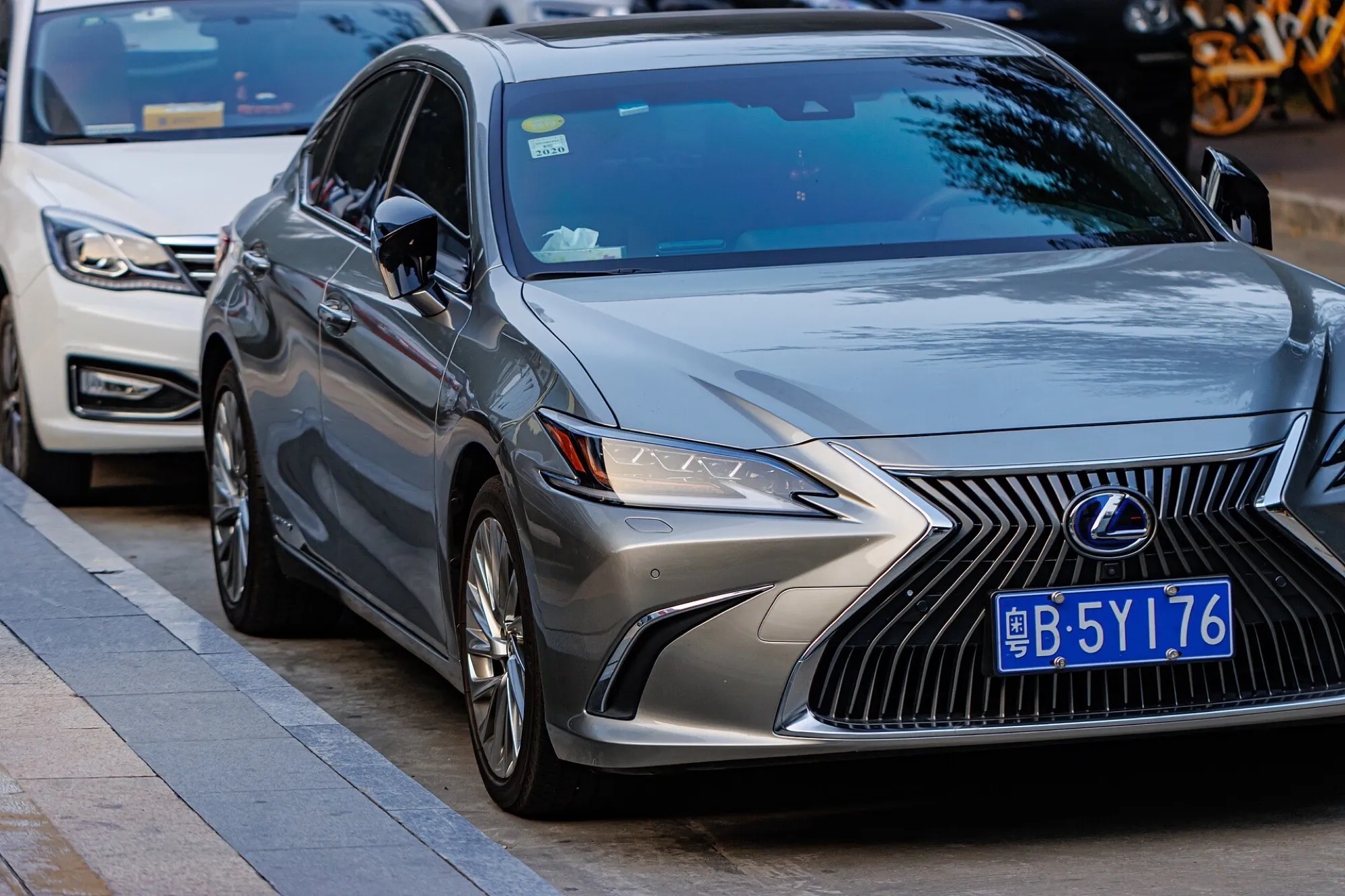 A grey Lexus ES 300h hybrid sedan parked at a kerb