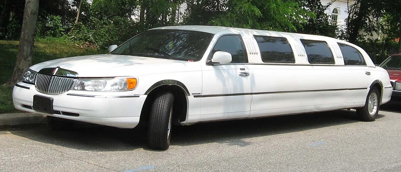 A white Lincoln Town Car stretch limousine parked at a kerb