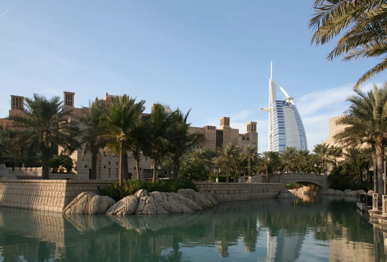 Madinat Jumeirah waterways and wind towers, with the Burj Al Arab behind the palms