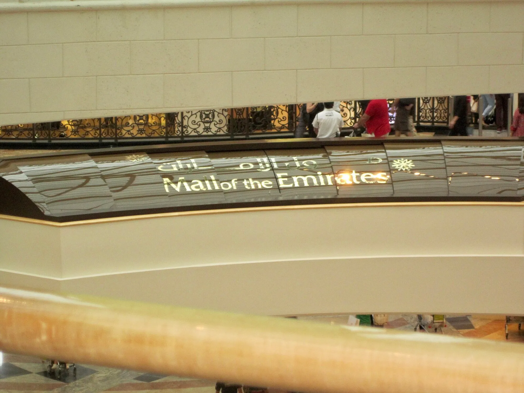 The Mall of the Emirates name in English and Arabic on a curved balcony inside the mall
