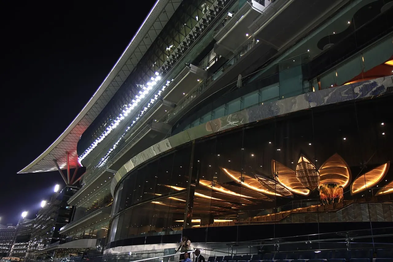 The grandstand at Meydan Racecourse in Dubai lit up at night