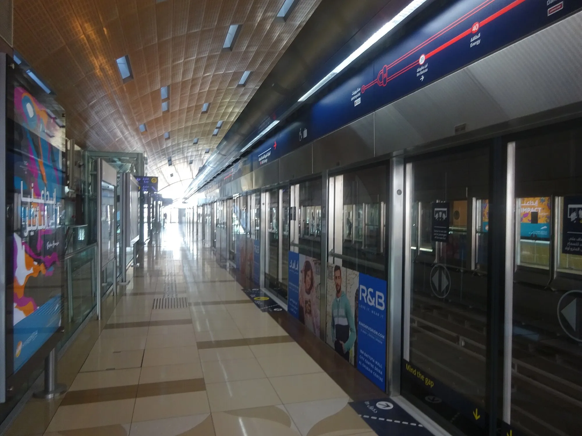 The long platform at Ibn Battuta Metro station with screen doors and a Red Line map above them