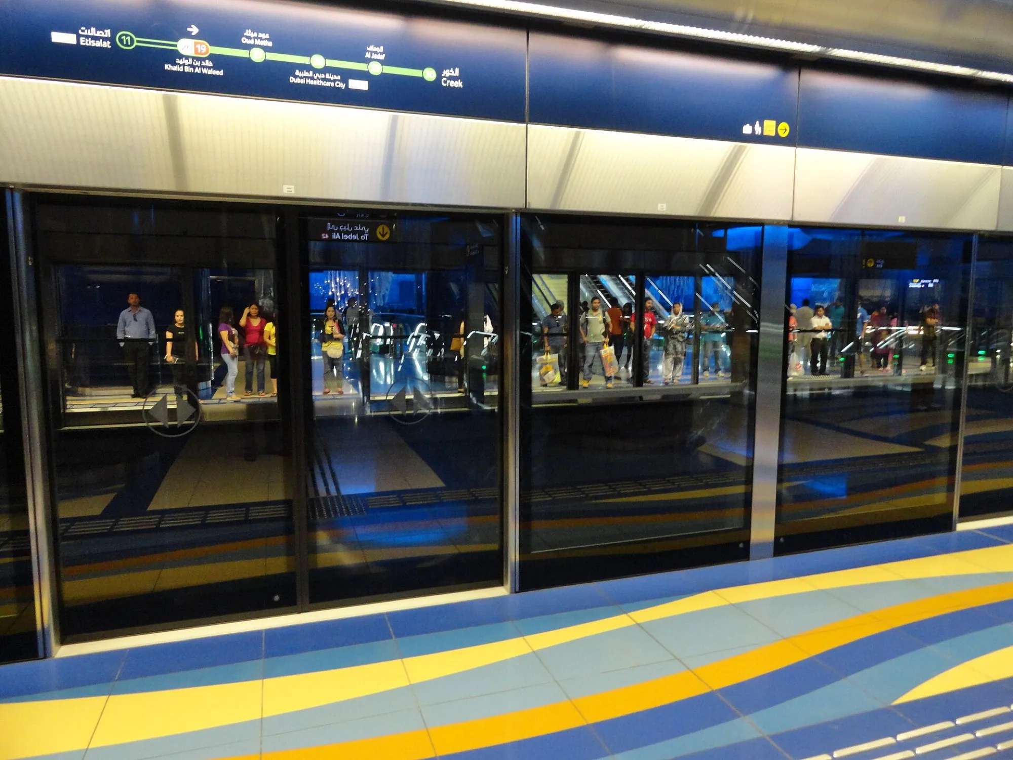 Platform screen doors at a Dubai Metro station with the Green Line route map overhead