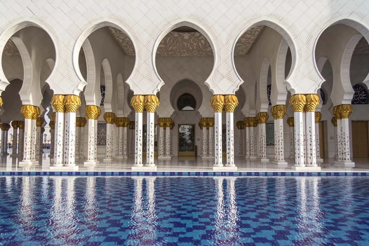Marble columns with gold capitals beside the reflecting pool at the Sheikh Zayed Grand Mosque in Abu Dhabi