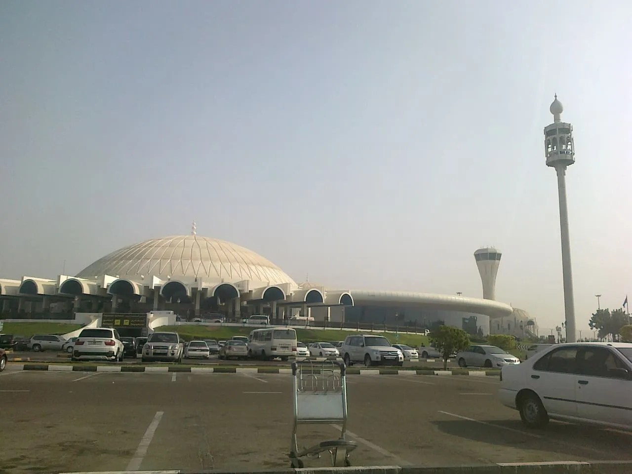 Cars parked in front of the domed passenger terminal at Sharjah International Airport